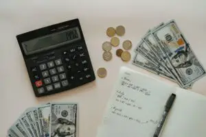 calculator,notebook and cash as tools to create and track your budget